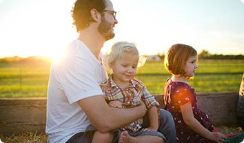 a person and two children sitting on a bench