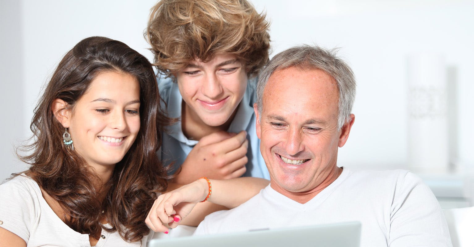 Father and kids looking at computer for life insurance options