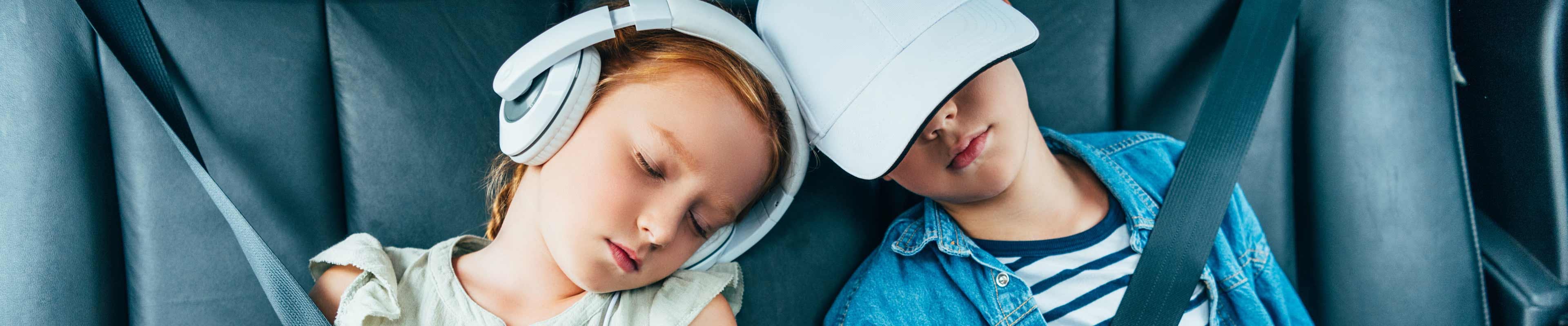 Siblings in the back seat of a car sleeping