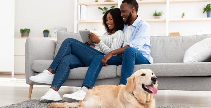 a man and a woman sitting on a couch with a dog